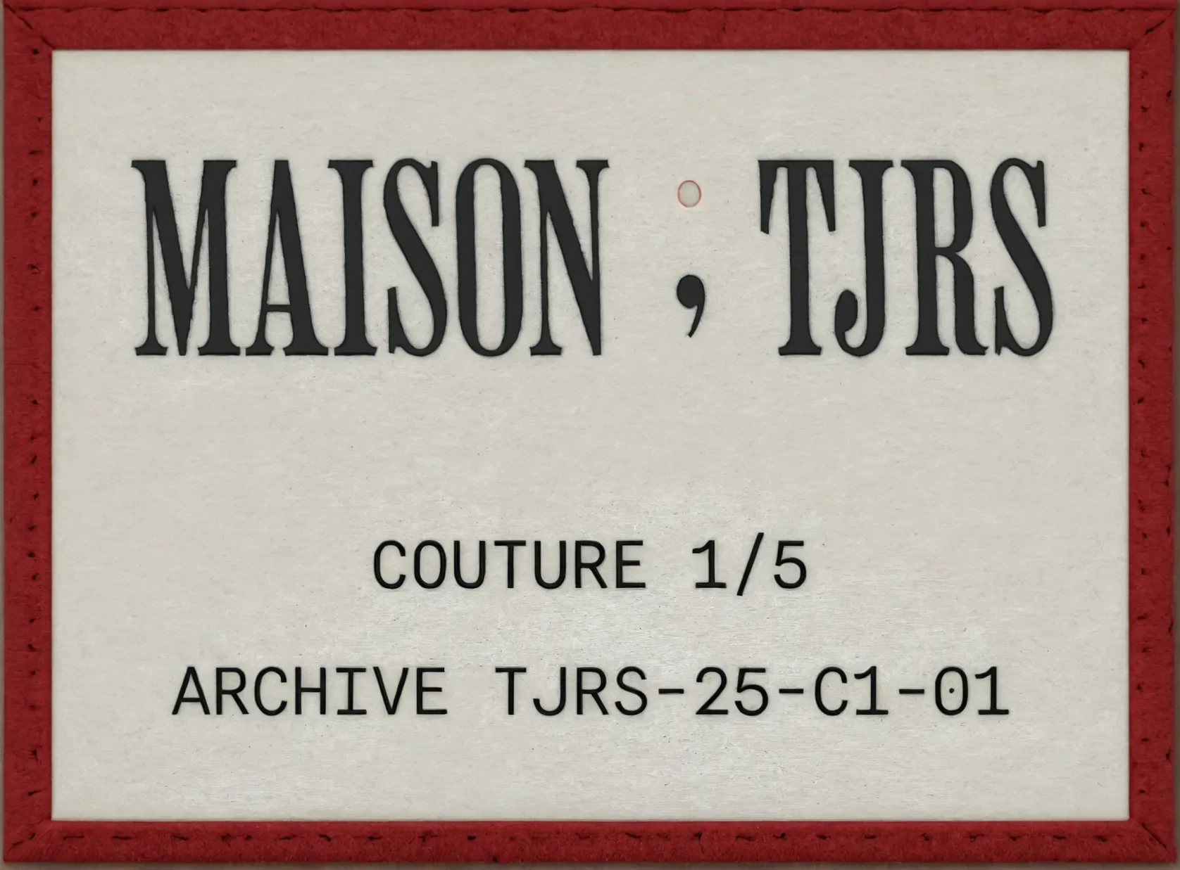 The Maison; TJRS label: the wordmark over COUTURE 1/5 and ARCHIVE TJRS-25-C1-01, in an oxblood frame.